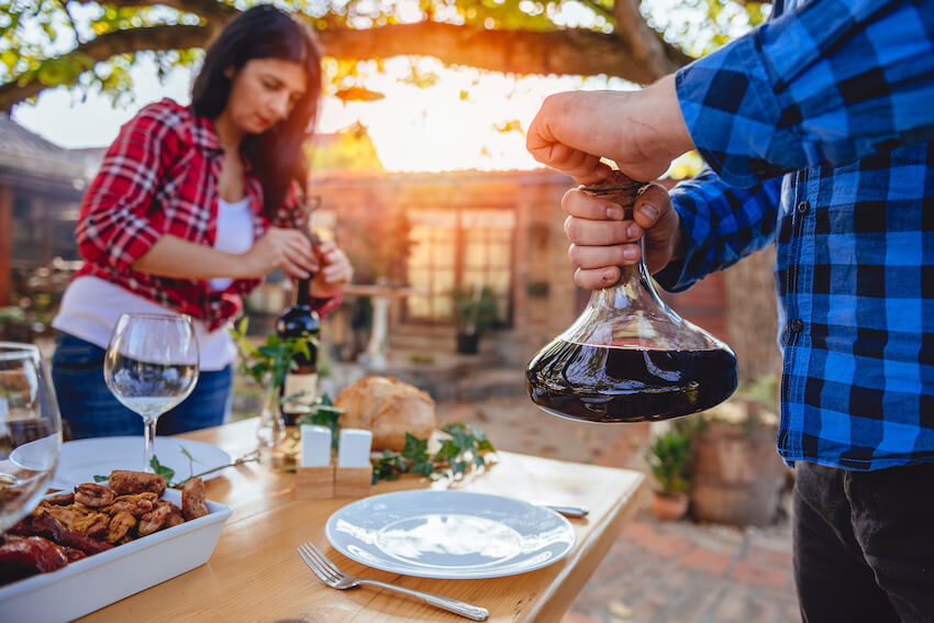 Engagement gift ideas: person opening a bottle of wine