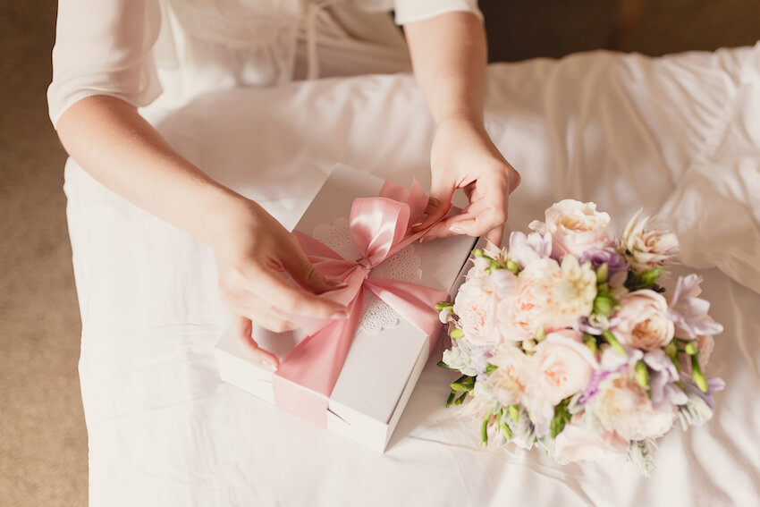 Wedding gift etiquette: person opening a gift