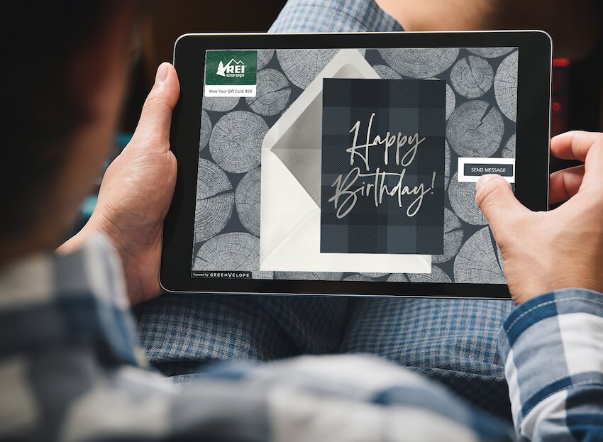 Virtual gift cards: person using a tablet with Greenvelope's invitation card on the screen