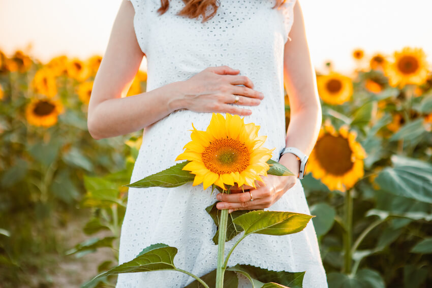 Sunflower baby shower: pregnant woman holding a sunflower