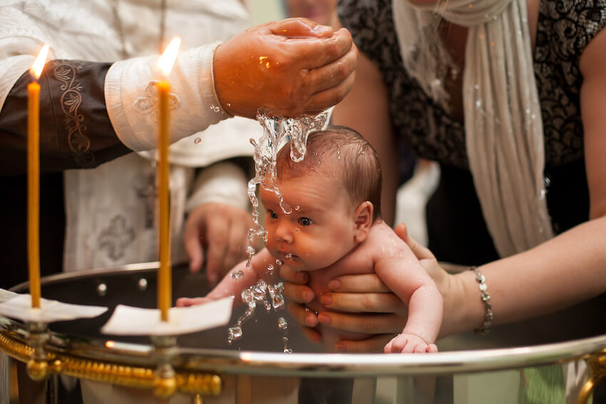 Baby's baptism: priest baptizing a baby