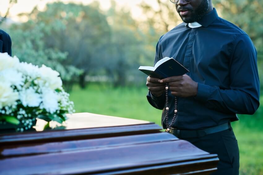 Funeral service announcement: priest reading scripture from the Bible for a funeral