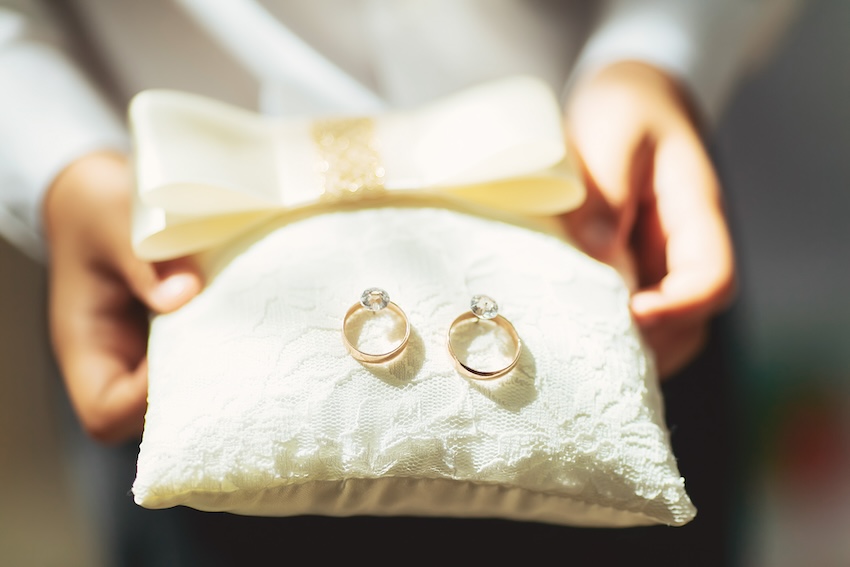 Ring bearer carrying 2 wedding rings on a small pillow