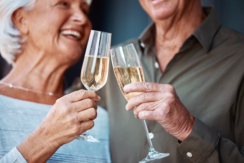 50th wedding anniversary gifts: senior couple clinking their glasses