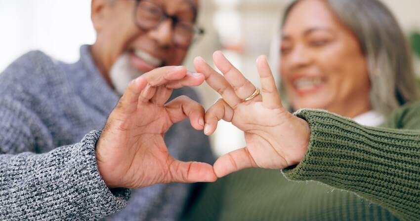 Anniversary gift for parents: senior couple doing the heart shape using their hands