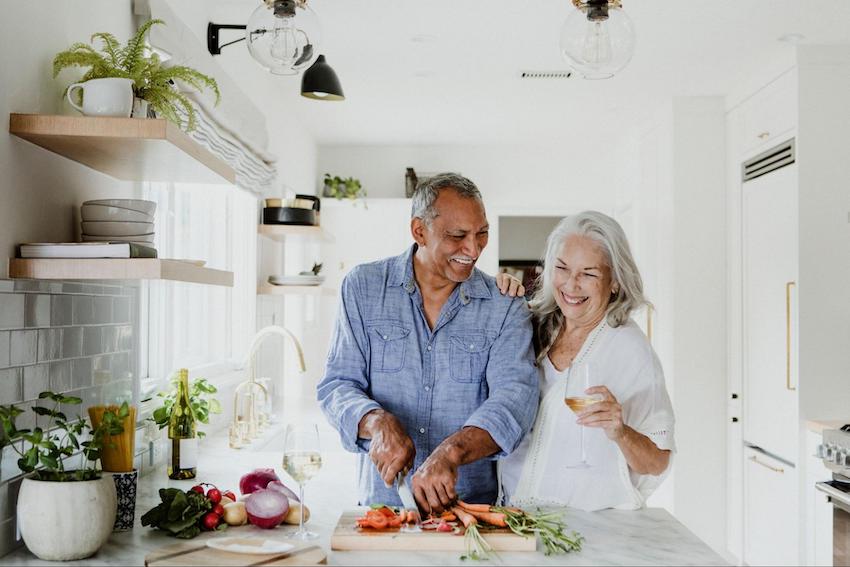 Romantic happy Valentines Day: senior couple happily chopping vegetables
