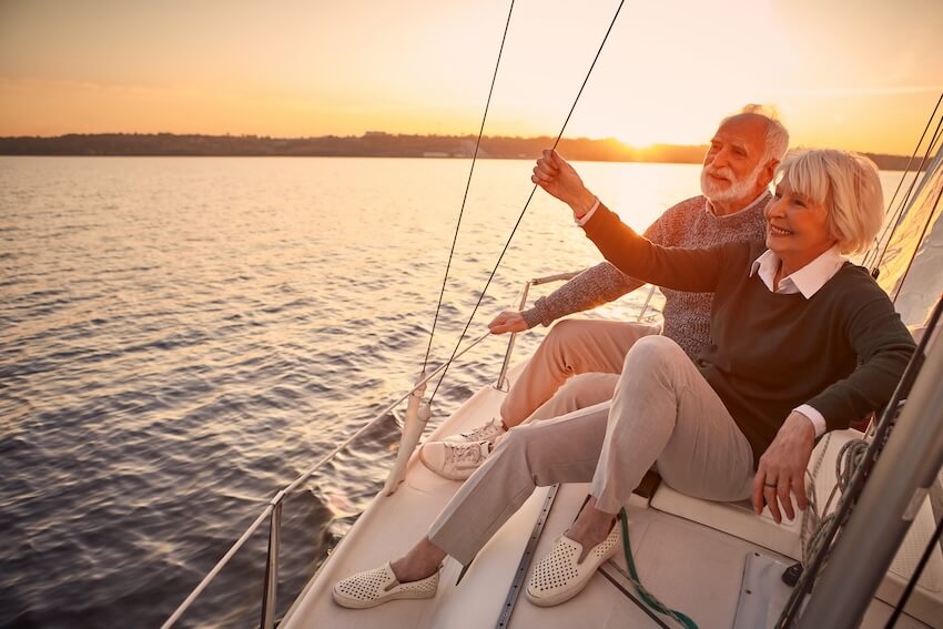 Senior couple happily sailing in their yacht