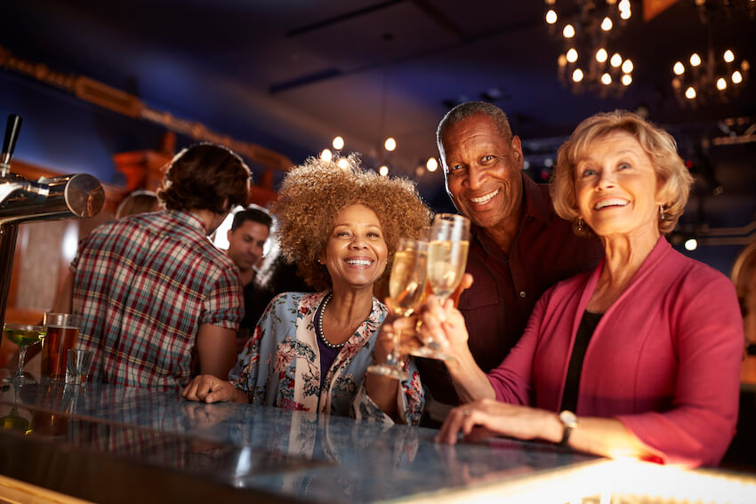 Senior people happily drinking at a bar