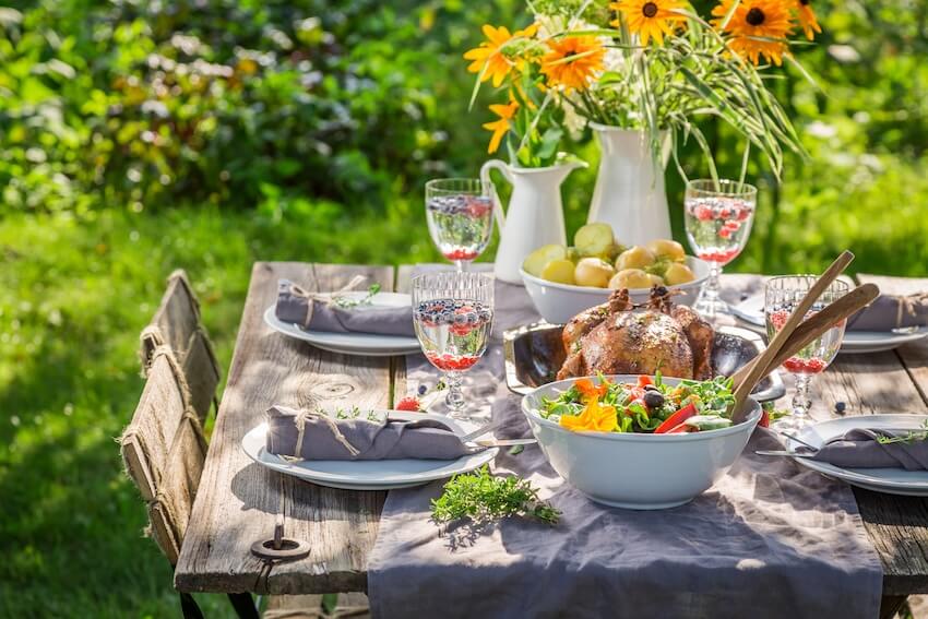 Table setting with a bowl of salad and a whole roasted chicken