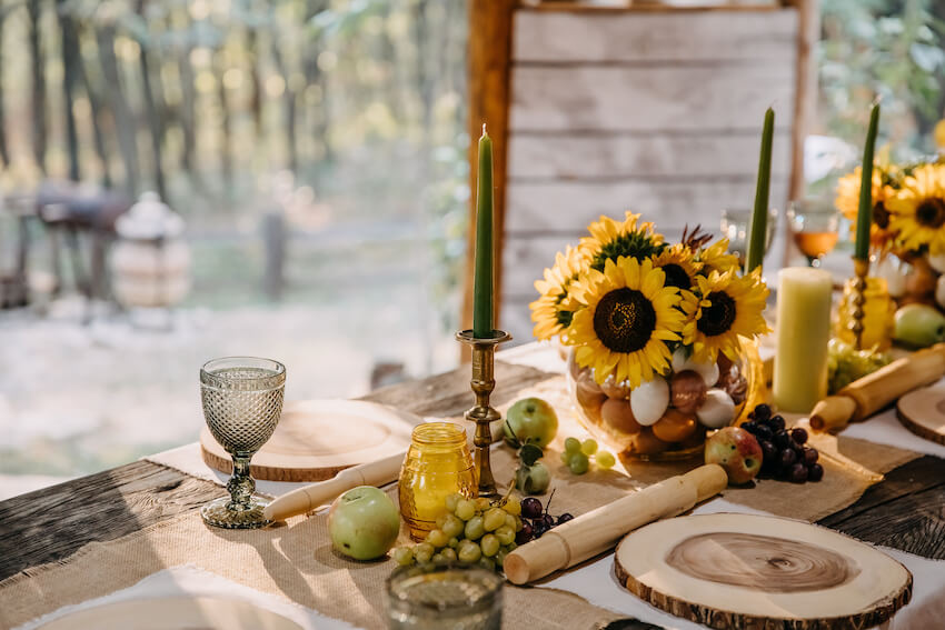Table setting with sunflowers, candles, and wooden plates