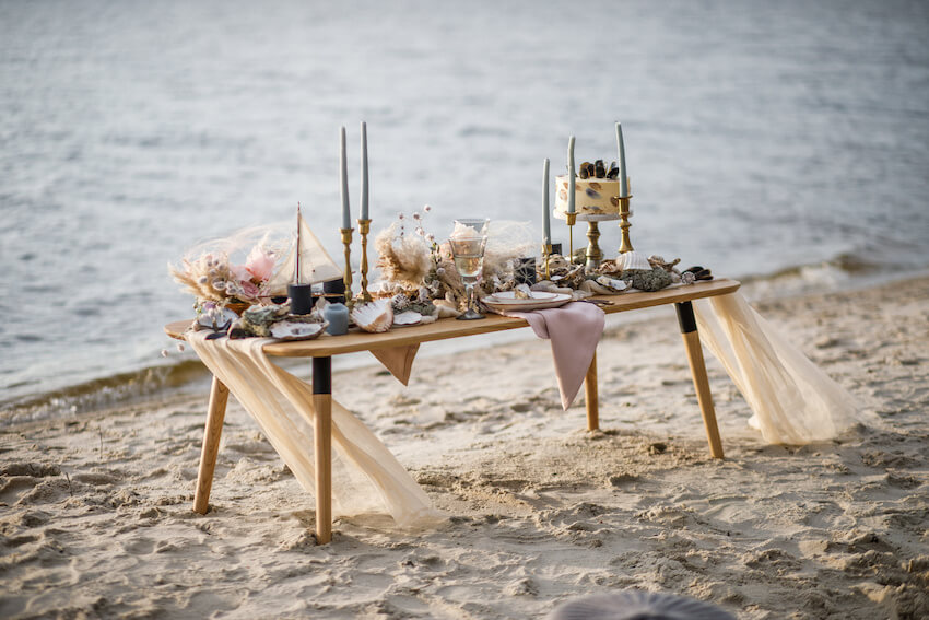 Beach wedding: table with food and candles on a beach