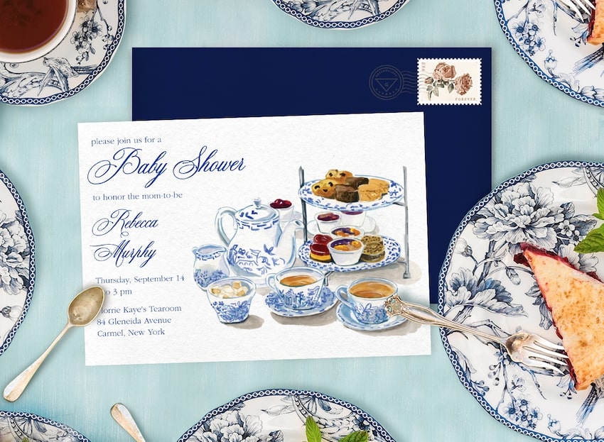Tea party baby shower invitation and food on a table