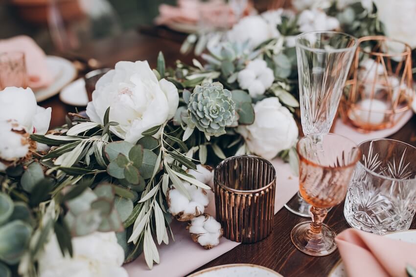 Various glasses and flowers on a table