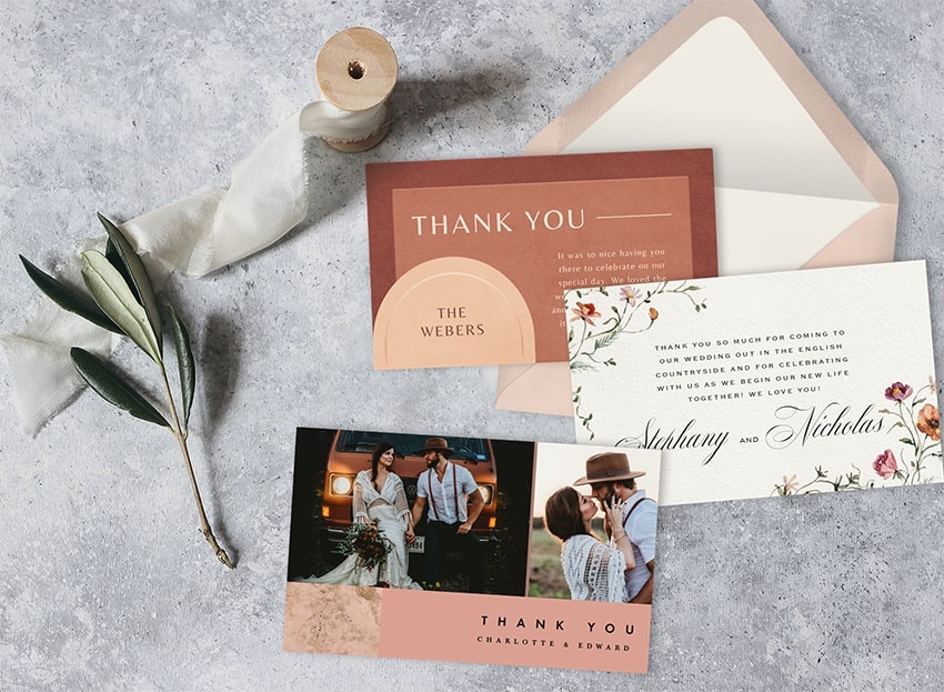 Wedding thank you notes, an envelope, and a vine on a table