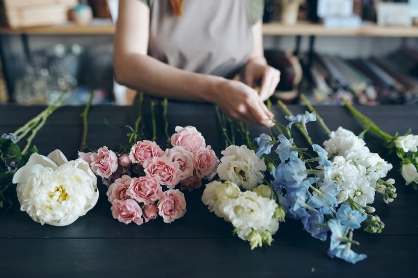Woman arranging various flowers