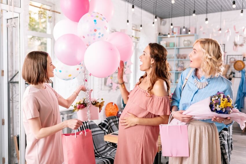Baby shower ideas for girls: woman giving gifts to her pregnant friend
