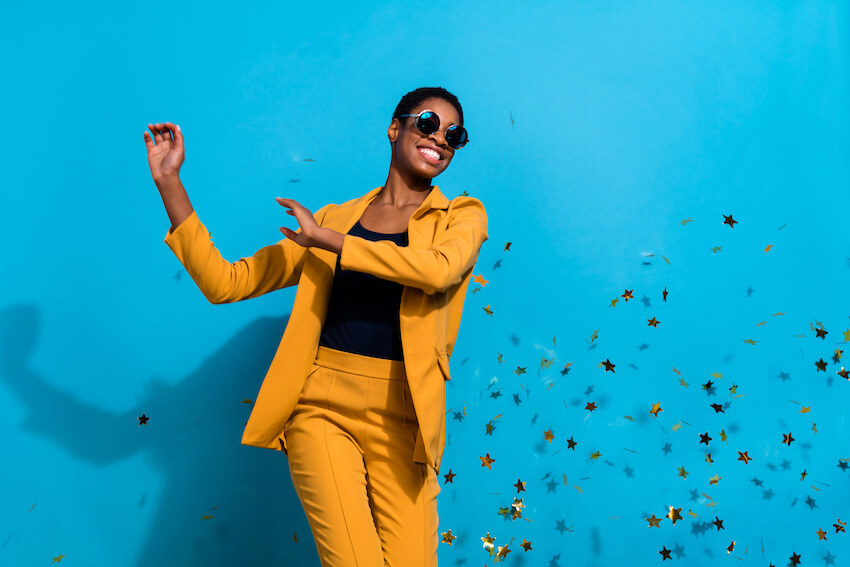 Woman happily posing at the camera with confetti in the background