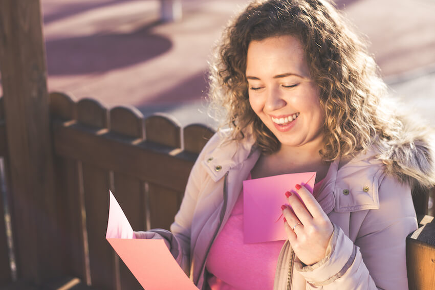 Bridesmaid proposal cards: woman happily reading an invitation card