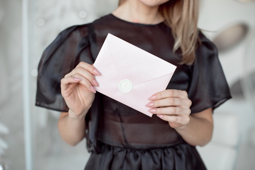 Affordable wedding invitations: woman holding a wedding invitation