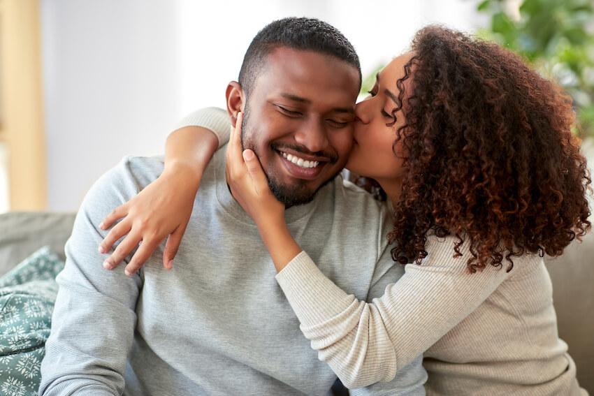 Anniversary ideas: woman kissing her boyfriend