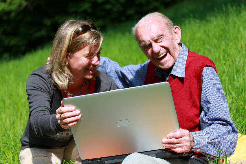 Woman showing a laptop to her father