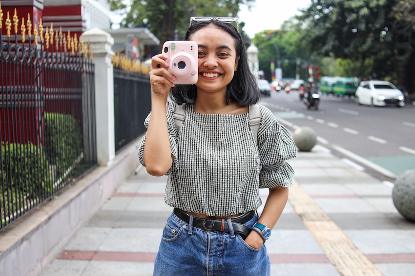 Woman using a pink Instax