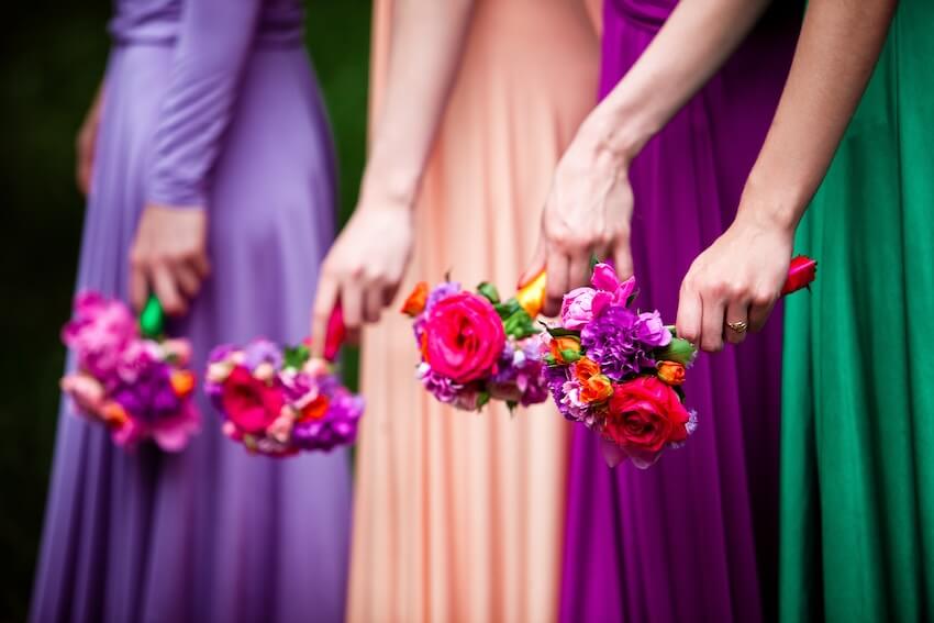 Non white wedding dresses: women holding colorful bouquets