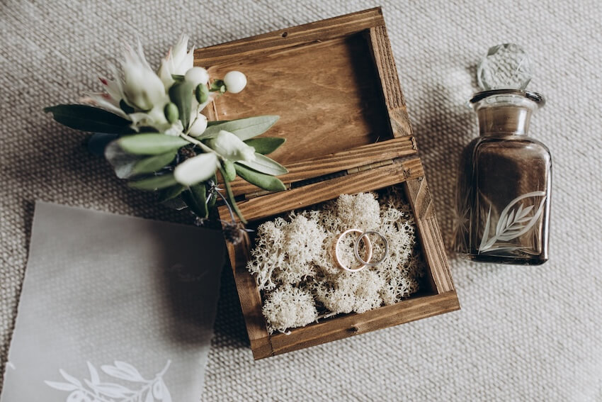 Anniversary themes by year: wooden box with wedding rings and flowers on a table